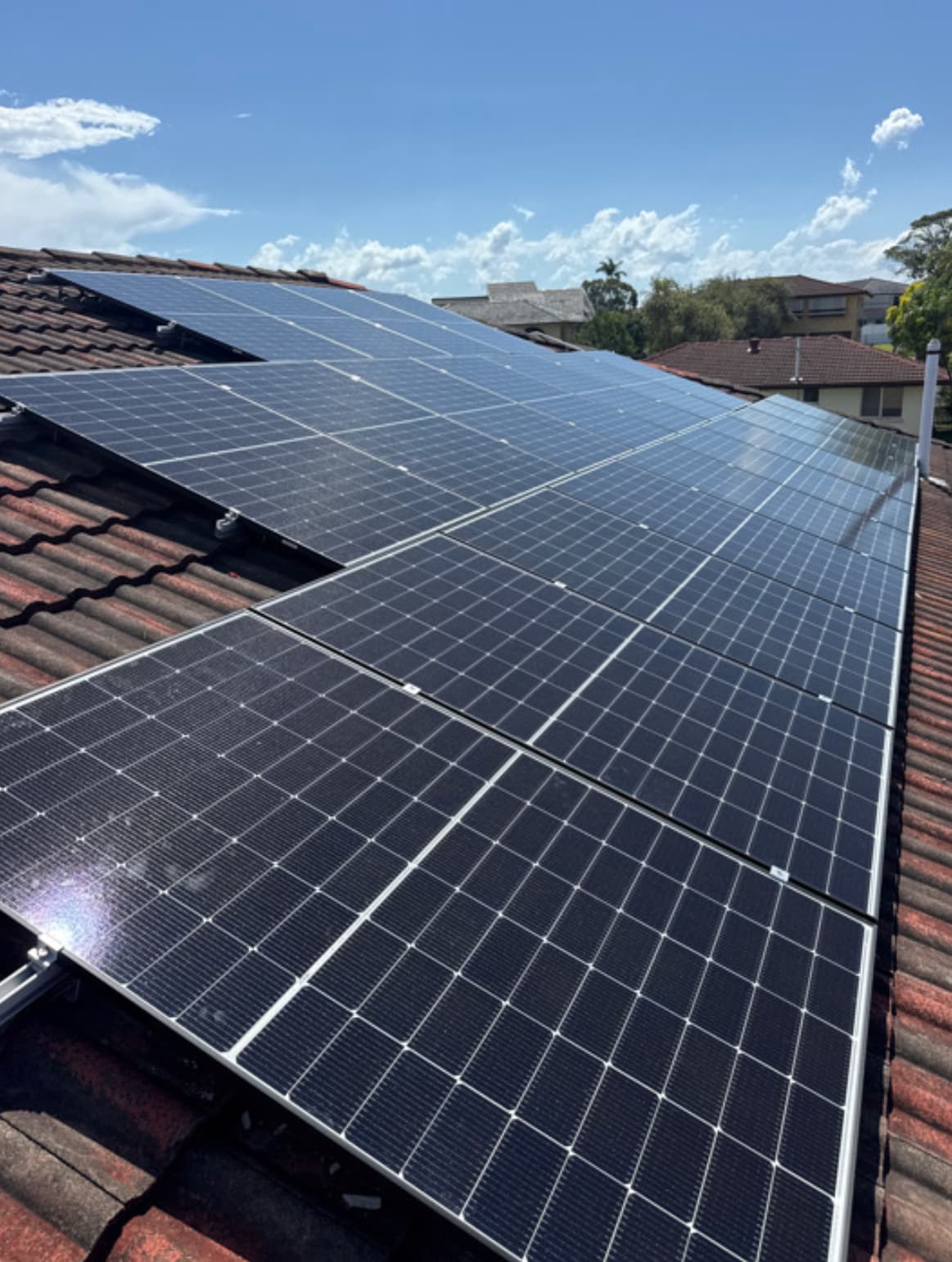 Rooftop solar panel array against a clear blue sky