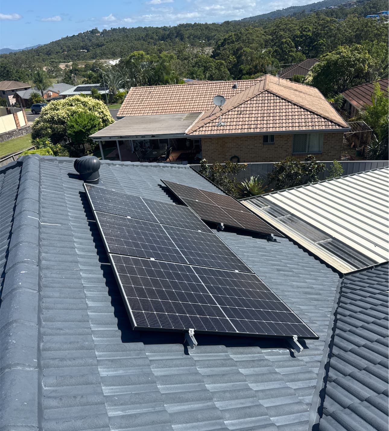 Rooftop solar installation overlooking a Brisbane valley suburb